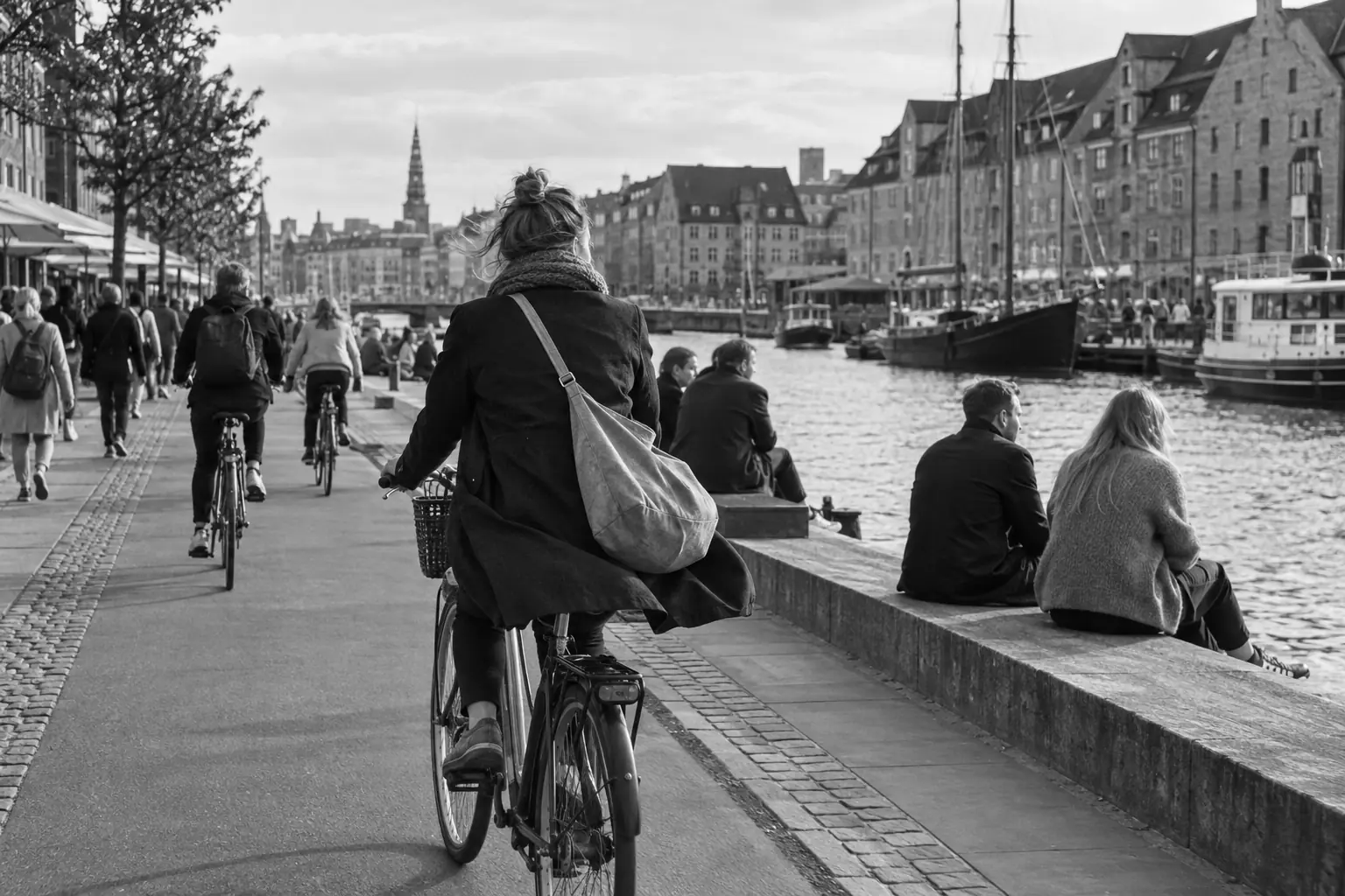 Illustration: a cyclist riding along the Copenhagen harbour on a bright morning